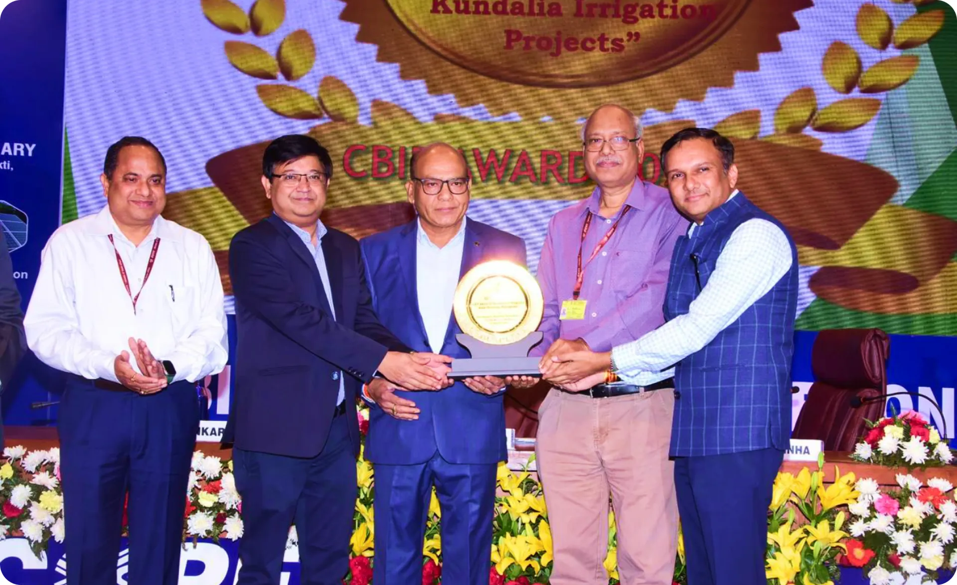 Project officials receiving the CBIP Award 2025 in front of the Mohanpura–Kundalia Irrigation Projects backdrop